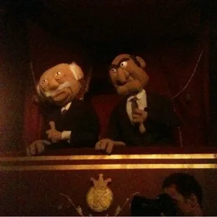 puppets of three men in tuxedos on a stage