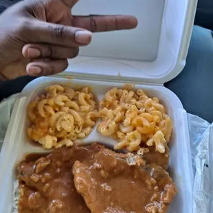 Smothered pork chop with rice and mac and cheese . And my peace  sign lol