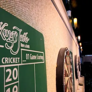 the scoreboard and darts on the wall