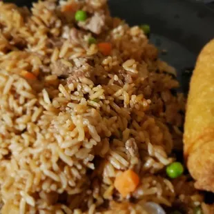 a plate of fried rice with meat and vegetables