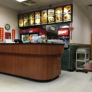 a restaurant counter with a menu in the background