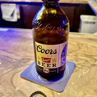 a bottle of beer on a coaster