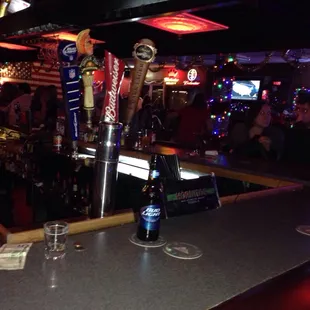 a bar with beer taps and people in the background