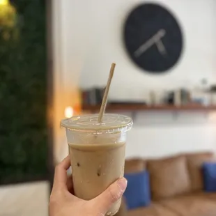 a hand holding a cup of iced coffee