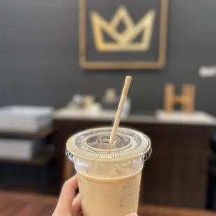 a hand holding a cup of iced coffee