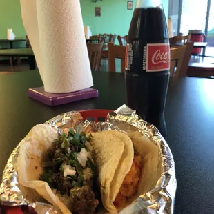 One barbacoa taco and one Mexican potato taco washed down with a Mexican Coke.