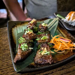 A5 Wagyu Beef Yakitori. $35. Tare sauce, garlic chip, shishito peppers, green onions.