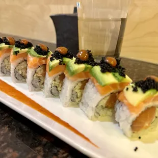 a sushi roll with salmon, avocado, and cavia