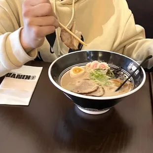 a person eating a bowl of ramen