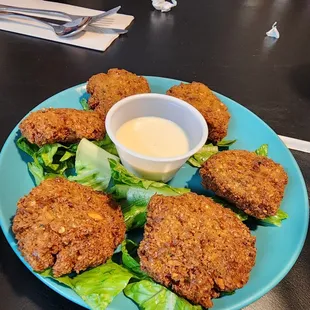 a plate of fried food and a bowl of dip