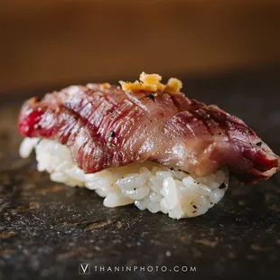 a piece of meat on top of rice