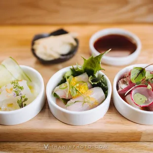 three bowls of food on a cutting board