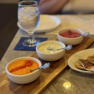 Mezze TrioE - Beetroot hummus, roasted red pepper feta dip and tzatziki dip with homemade pita.