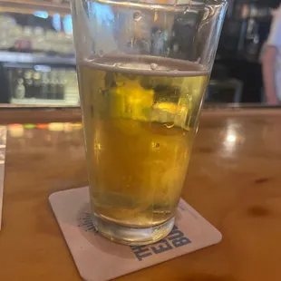 a glass of beer on a coaster