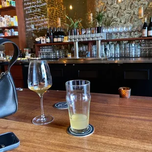 a glass of wine and a cell phone on a bar