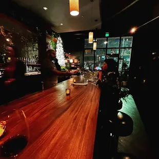 a glass of wine sitting on a bar