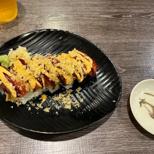 a hot dog with cheese and ketchup on a black plate