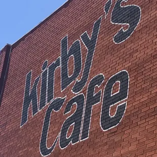 a brick building with a sign that says kirby&apos;s cafe