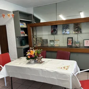 a table with a white tablecloth and red chairs