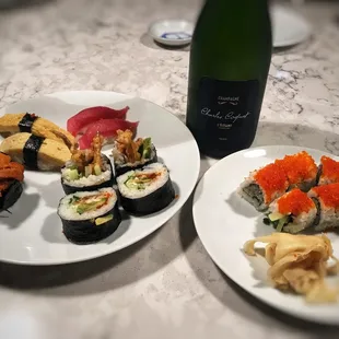 two plates of sushi and a bottle of wine