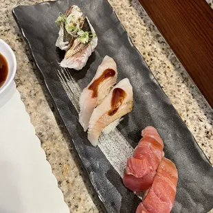 a plate of sushi and a bowl of sauce