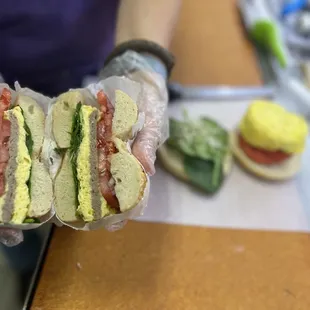 a person holding a sandwich