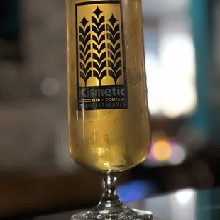 a glass of beer on a bar