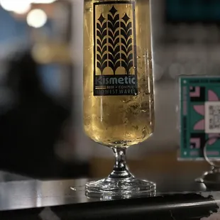 a glass of beer on a bar