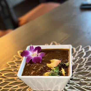 a bowl of chili with a flower on top