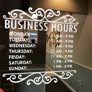 a business hours sign in a window