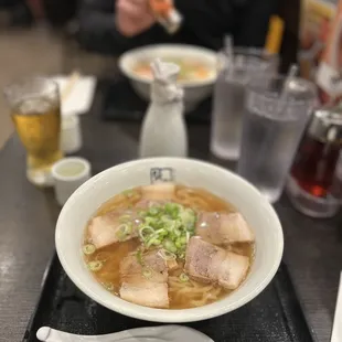 a bowl of ramen and a glass of beer