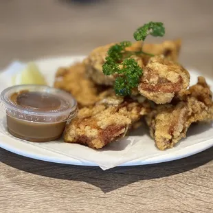 a plate of fried chicken with a side of dipping sauce