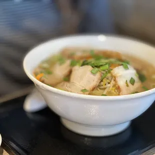 a bowl of ramen with tofu and green onions