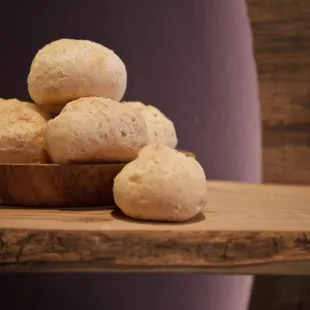 a wooden bowl filled with doughnuts