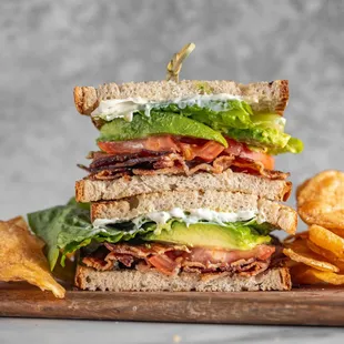 a sandwich on a cutting board with chips