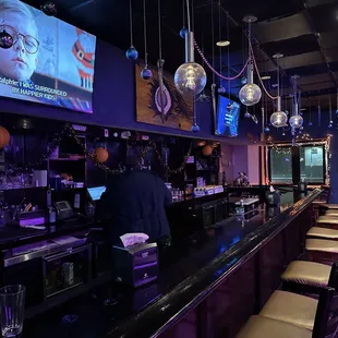 a bar with purple lighting and a television