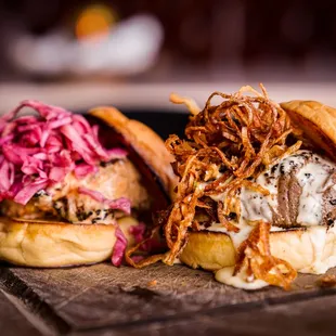 two burgers on a cutting board
