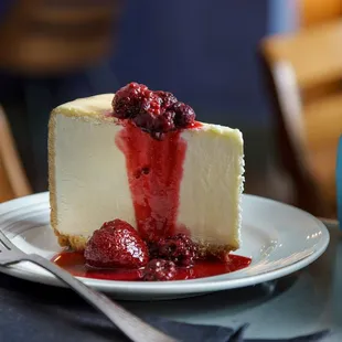 a slice of cheesecake with raspberry sauce