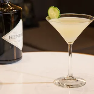 a cocktail with a cucumber garnish garnish