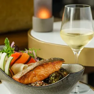 a bowl of food and a glass of wine