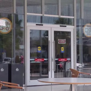 the outside of a restaurant with tables and chairs