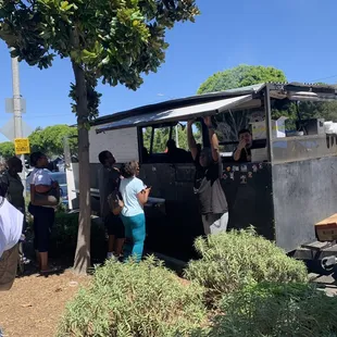 a group of people standing around a food truck