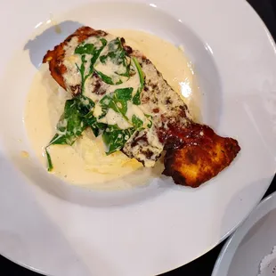 Honey glazed Salmon topped with cream sauce and spinach rested on mashed potatoes