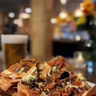 a plate of nachos and a glass of beer