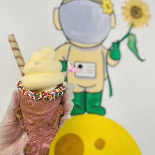 a hand holding an ice cream cone with sprinkles