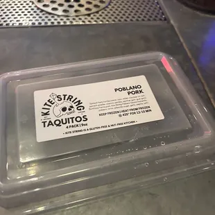 a plastic container of taquios