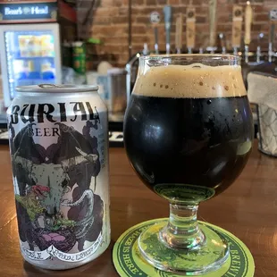 a glass of beer next to a can