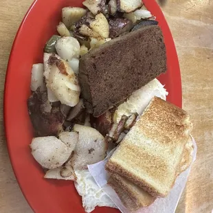 Two eggs over medium, potatoes with peppers and onions, scrapple and toast