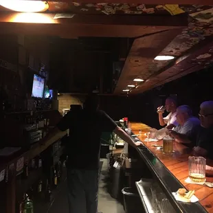 people sitting at a bar watching tv