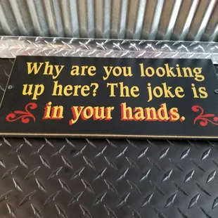 a sign that says why are you looking up here? the joke is in your hands